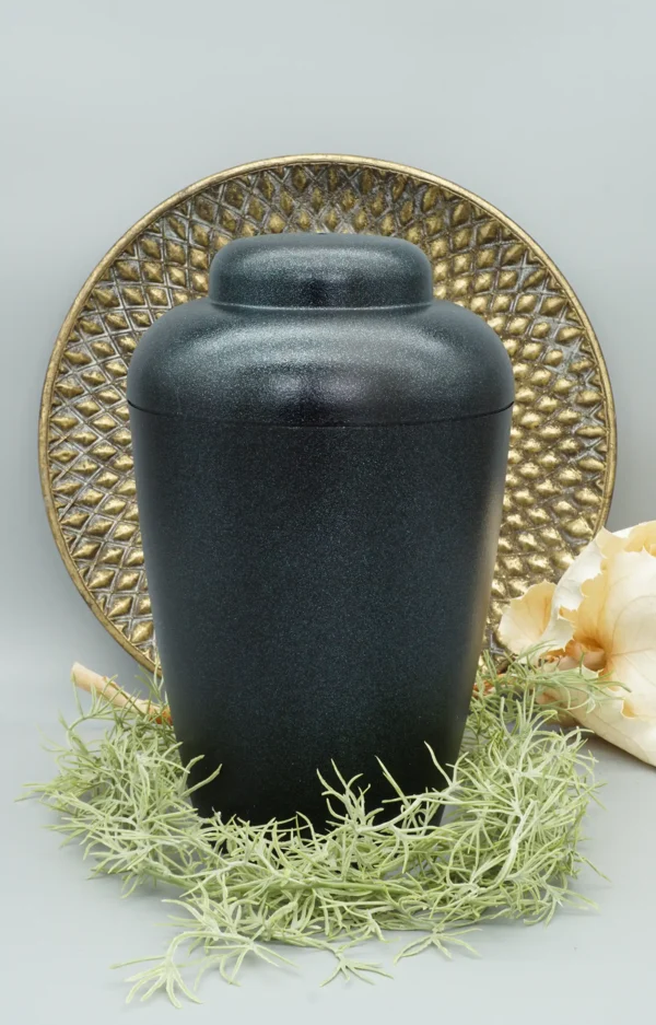 Bio Urne VALE schwarz mit blauem Glitzer mit dekorativem Hintergrund