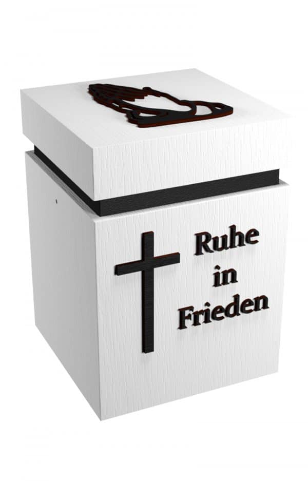 Holzurne in weiß mit schwarzem Kreuz und Spruch: Ruhe in Frieden