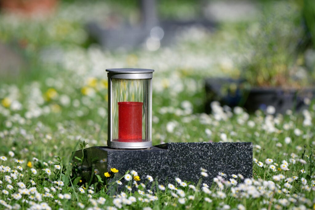 Urnengrab mit Kerze auf dem Grabstein